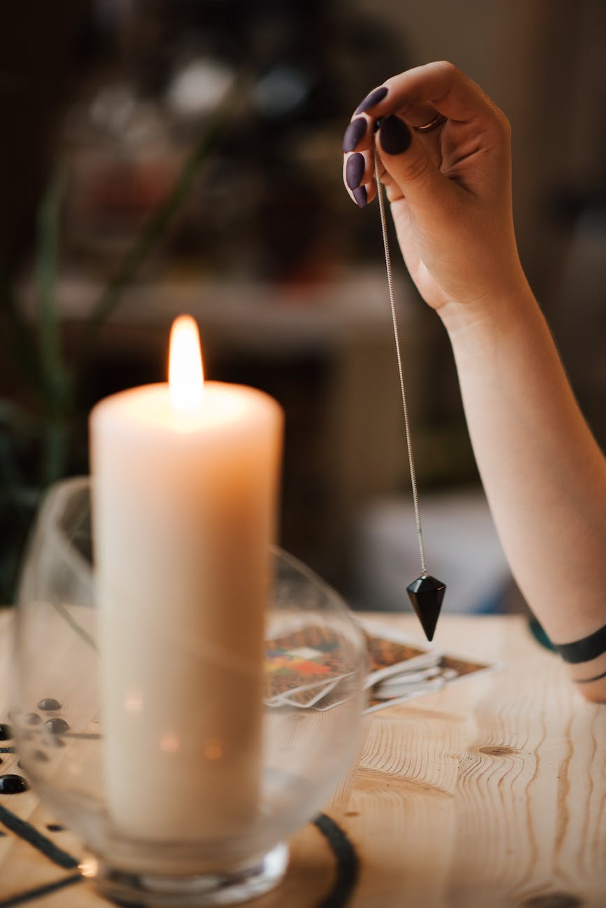 crop fortune teller with amulet near shiny candle